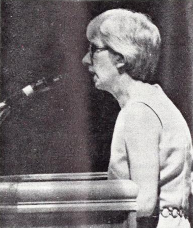 Cornelia Lehn standing in front of a microphone at a podium