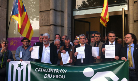 Mayors posing with their tax documents before the Catalan tax bureau, in a Catalunya Diu Prou tax resistance action