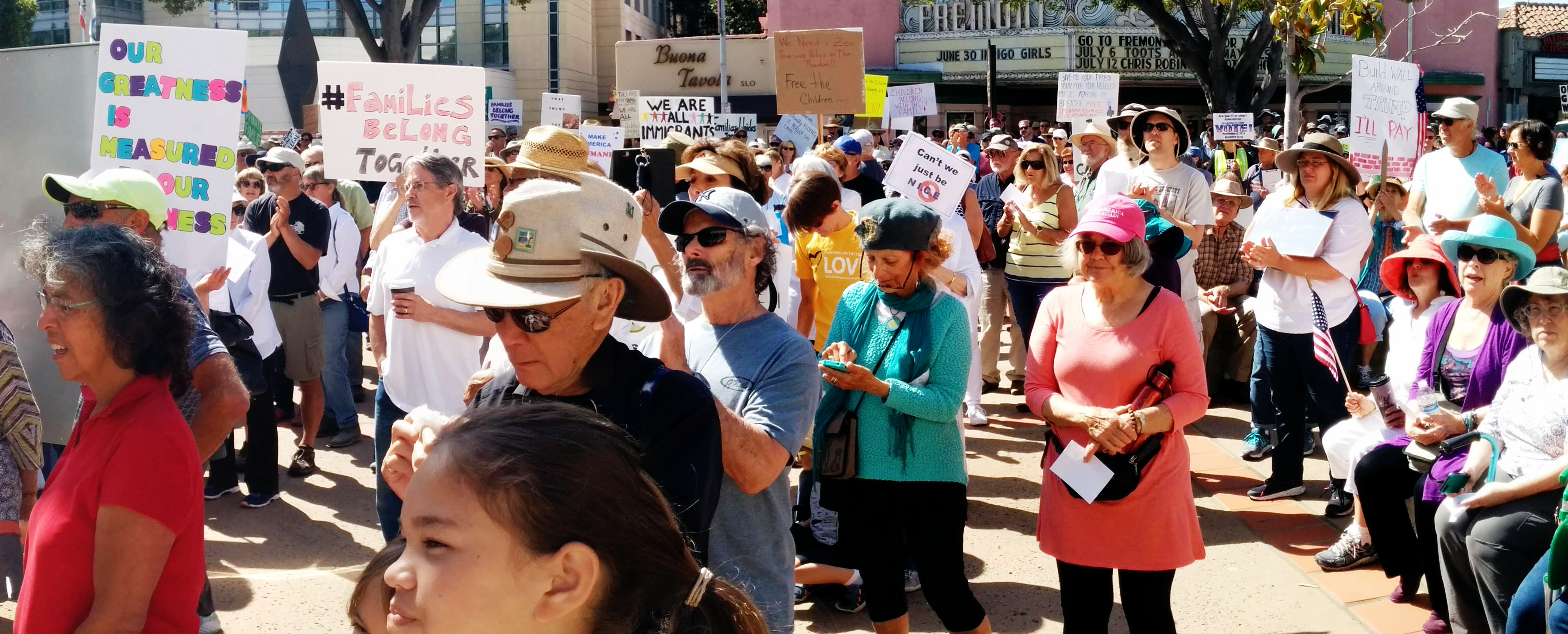 a crowd listens to speakers at the Families Belong Together rally in San Luis Obispo
