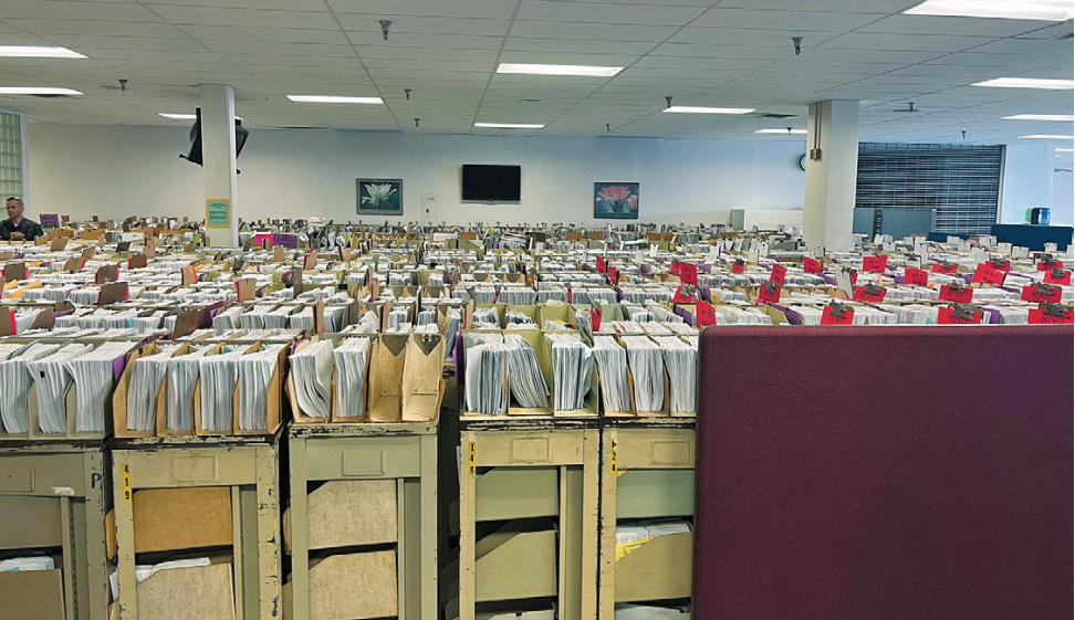 Photograph of the cafeteria of an I.R.S. facility in Austin with stacks of unprocessed returns as far as the eye can see.