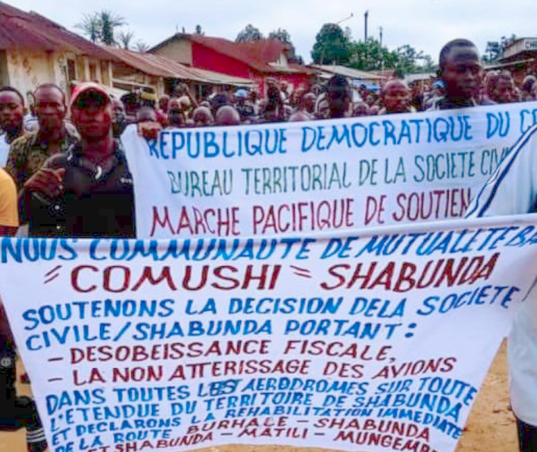protest marchers in South Kivu with banners announcing their airport blockade and tax strike