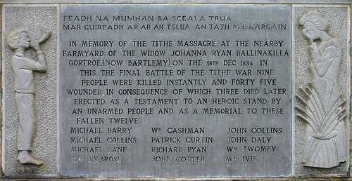 FEADH NA MUMHAN BA SCÉALA TRUA MAR CUIREADH AR AR AN TSLUA-AN TATH M. Ó HARGAIN. IN MEMORY OF THE TITHE MASSACRE AT THE NEARBY FARMYARD OF THE WIDOW JOHANNA RYAN BALLINAKILLA GORTROE, (NOW BARTLEMY), ON THE 18TH DEC 1834. IN THIS, THE FINAL BATTLE OF THE TITHE WAR, NINE PEOPLE WERE KILLED INSTANTLY AND FORTY FIVE WOUNDED IN CONSEQUENCE OF WHICH THREE DIED LATER. ERECTED AS A TESTAMENT TO AN HEROIC STAND BY AN UNARMED PEOPLE AND AS A MEMORIAL TO THESE FALLEN TWELVE: MICHAEL BARRY, MICHAEL COLLINS, MICHAEL LANE, WM AMBROSE, WM CASHMAN, PATRICK CURTIN, RICHARD RYAN, JOHN COTTER, JOHN COLLINS, JOHN DALY, WM TWOMEY, WM IVIS